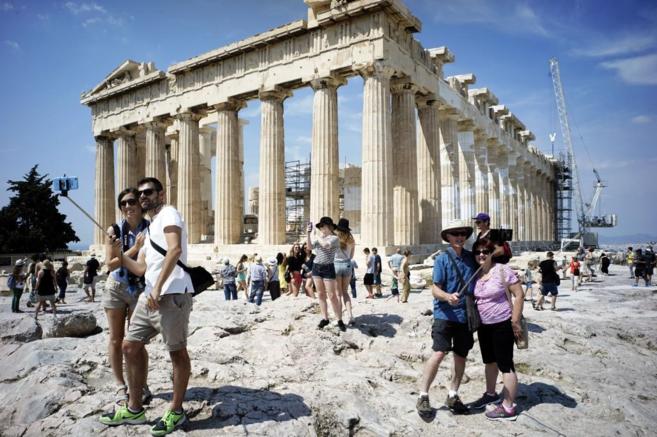 Turistas visitando el Partenón, en la Acrópolis de Atenas, durante...