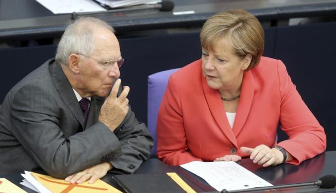 La canciller alemana, Angela Merkel, conversa con su ministro de...
