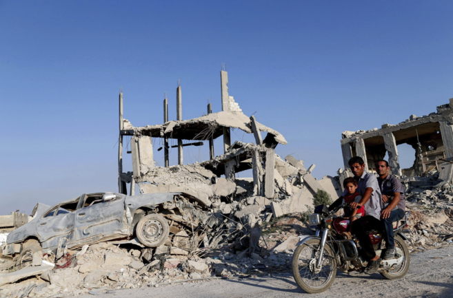 Una familia siria entre las ruinas de la ciudad de Kobani, al este del...