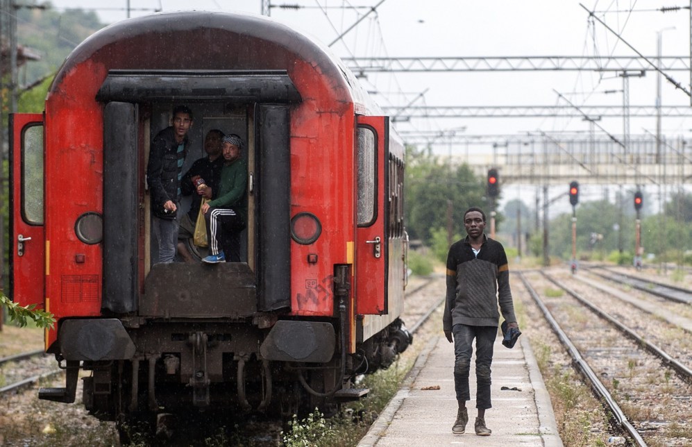 Inmigrantes caminan por la estacin de tren de Gevgelija, ciudad...