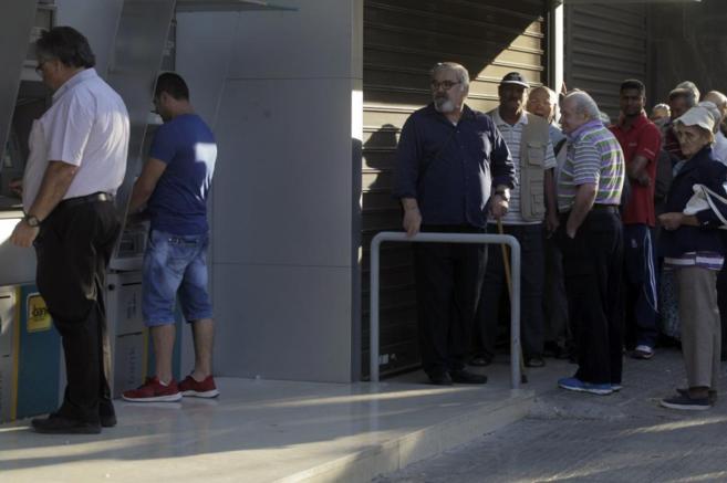 Ciudadanos griegos hacen cola ante una sucursal del Banco Nacional de...