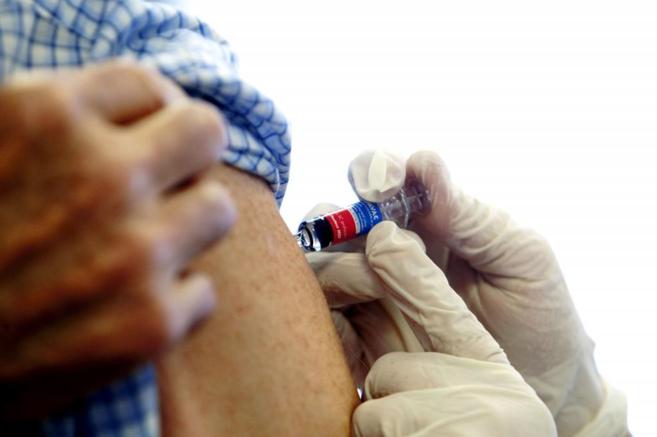 Un paciente recibe una dosis de una vacuna contra la gripe A H1N1.