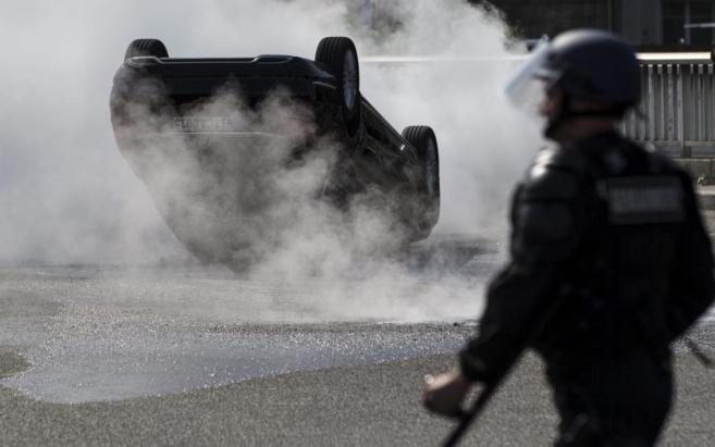 Taxistas franceses contemplan un vehculo ardiendo de Uber en Pars.