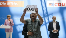 Uno de los manifestantes griegos en plena intervencin de Merkel