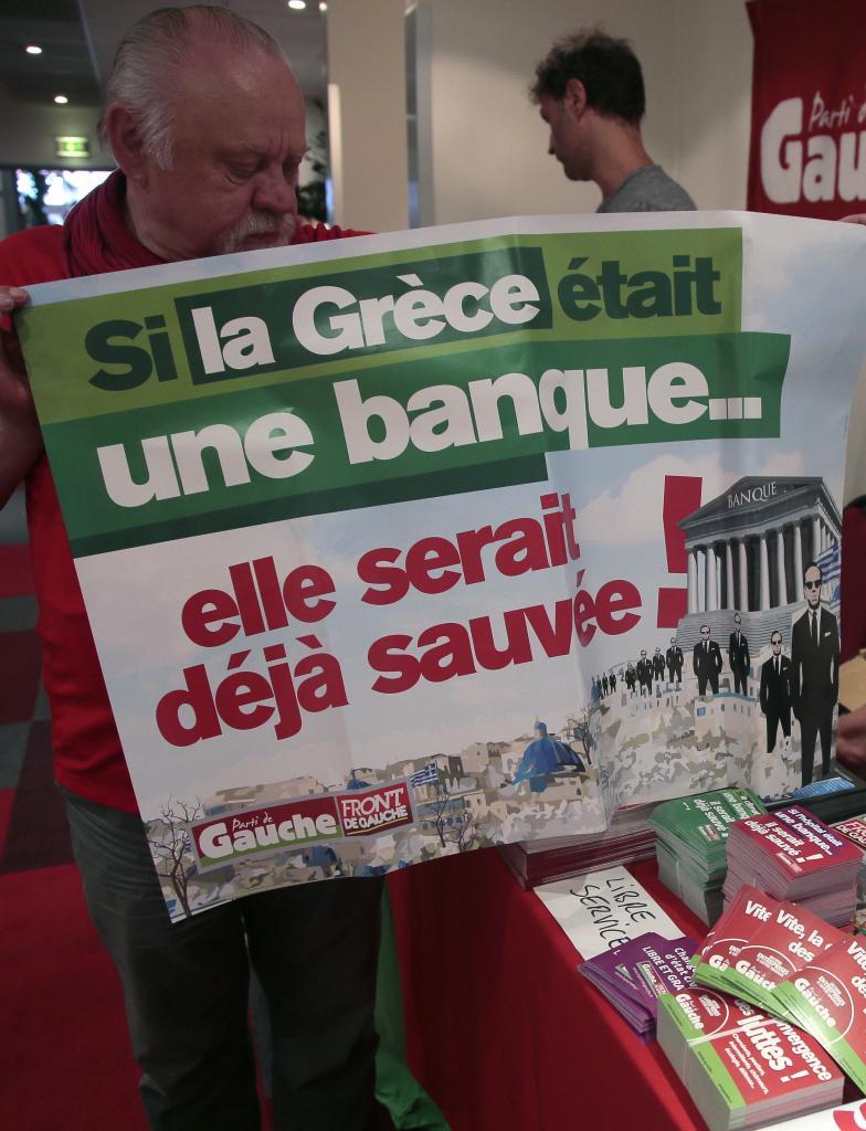 Un hombre sostiene un cartel que dice "Si Grecia fuera un banco, ella...