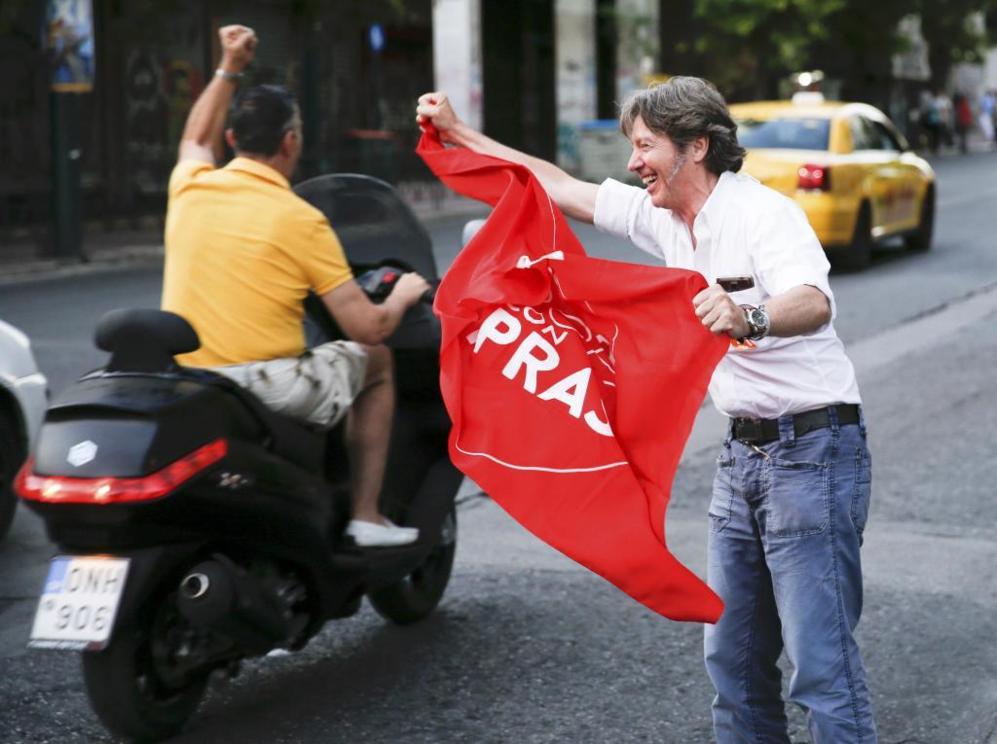 Un hombre partidario del 'No', en Atenas, ondea una bandera con el...