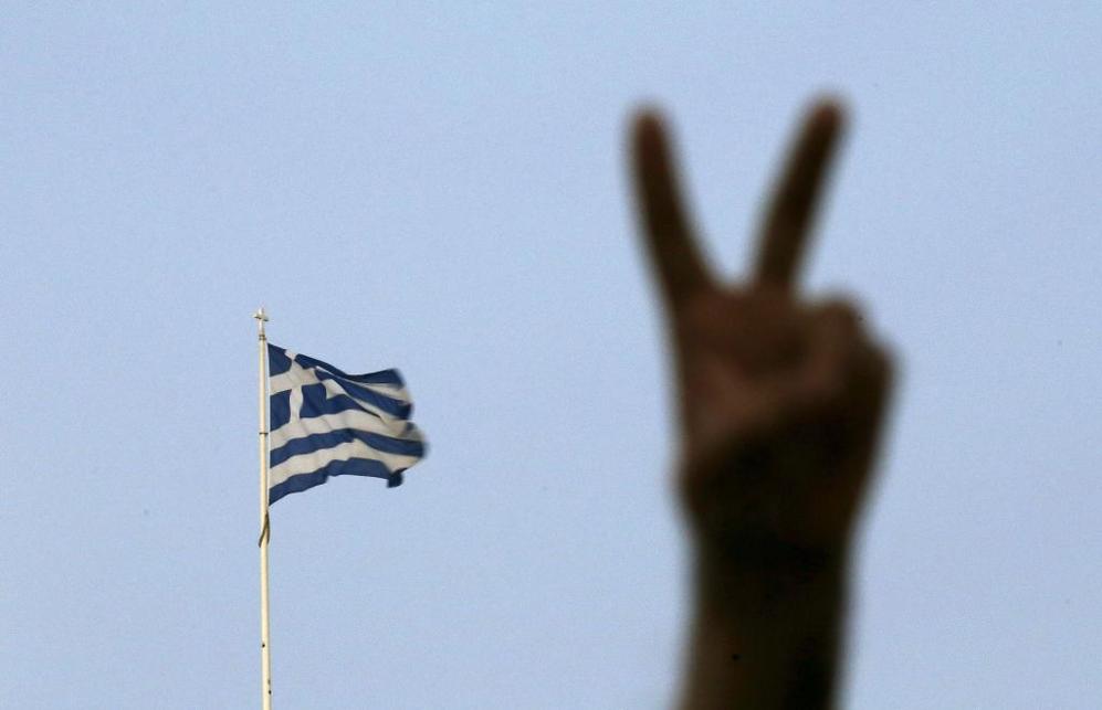 Con la bandera de Grecia de fondo, un partidario del 'No' realiza con...