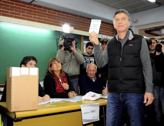 Mauricio Macri se dispone a depositar su voto en la urna este domingo...