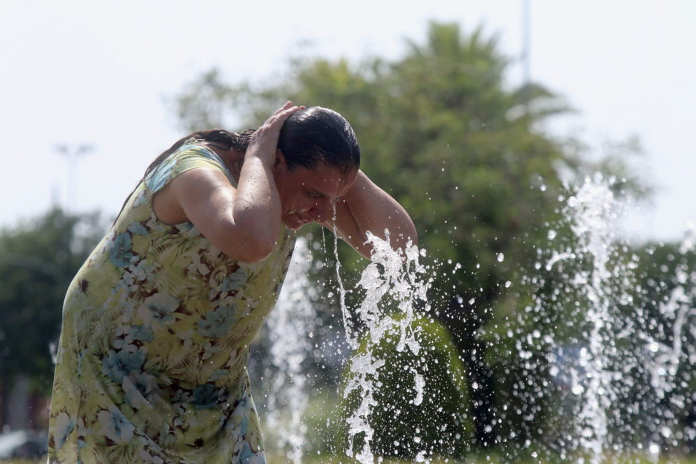 Una mujer intenta combatir el calor en una fuente de Crdoba.