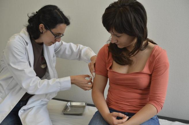 Una especialista inocula a una ciudadana en el centro de Vacunacin...