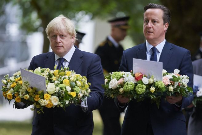 Boris Johnson y David Cameron sostienen ofrendas florales en un acto...