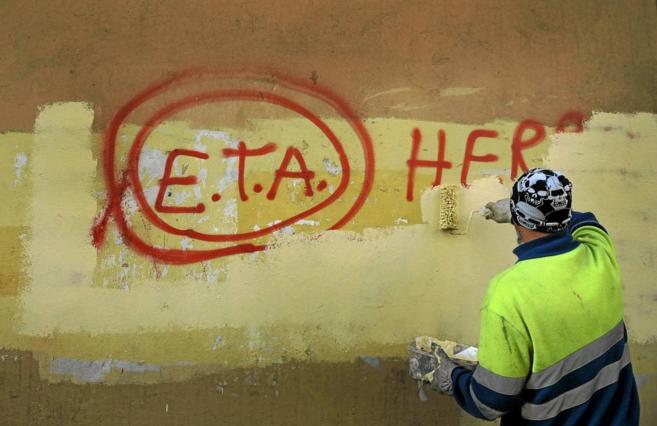 Un operario borra una pintada alusiva a ETA en un municipio de...