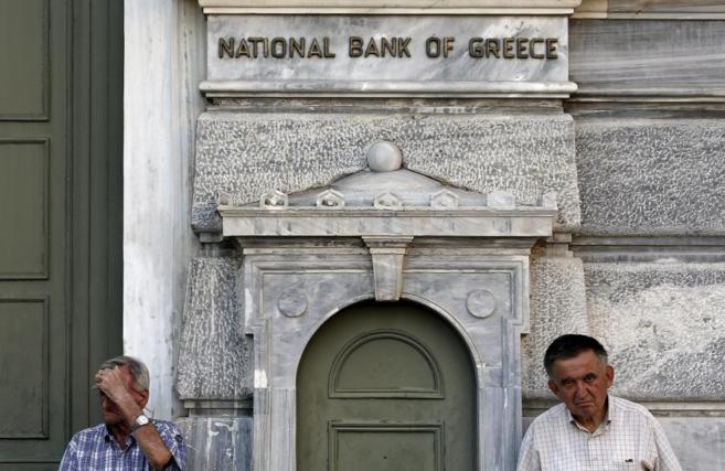 Dos pensionistas aguardan frente a un banco cerrado por el corralito.