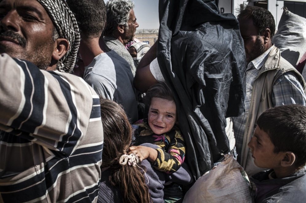 Refugiados kurdos de la ciudad de Kobani esperan en la frontera para...