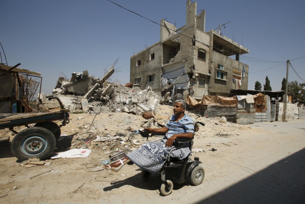 Un palestino pasea en silla de ruedas tras perder doce miembros de su...