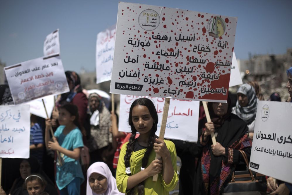 Una nia palestina porta una pancarta con el nombre de las mujeres...