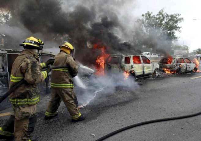 Bomberos apagan el fuego en un narcobloqueo del Cartel de Jalisco...