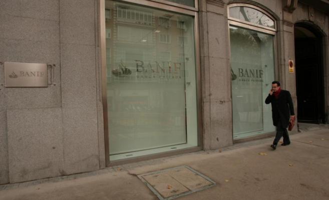 Un hombre pasea junto a una oficina de Banif en Madrid