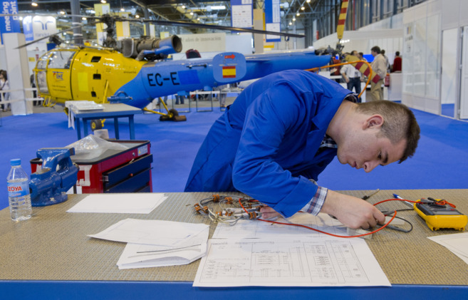 Un joven trabaja en una fbrica aeronutica.