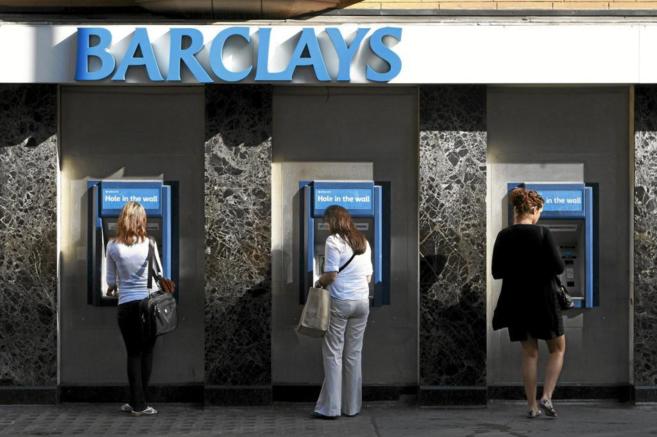 Varios clientes utilizan los cajeros de Barclays instalados en la sede...
