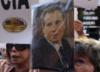 Una mujer sostiene una foto del fiscal argentino Alberto Nisman en una...