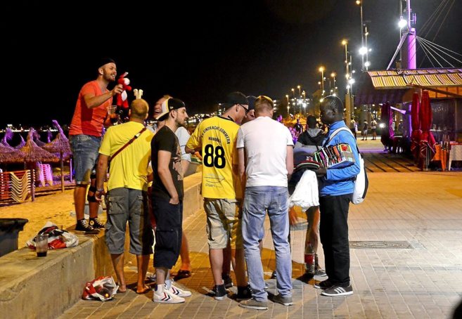 Un grupo de turistas habla con un vendedor ambulante durante la noche...