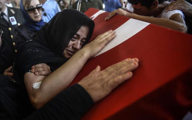 La esposa de un soldado turco fallecido en los choques, durante su...