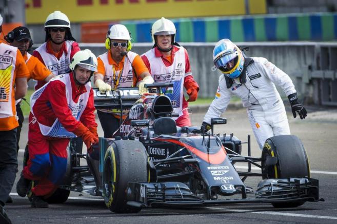 Fernando Alonso, empuja su McLaren camino de los 'boxes', en...