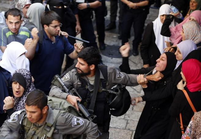 Un agente forcejea con una mujer palestina en los disturbios en...