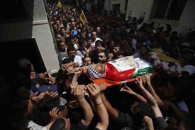Una muchedumbre cargan el cuerpo de Mohamed Abu Latifa durante su...