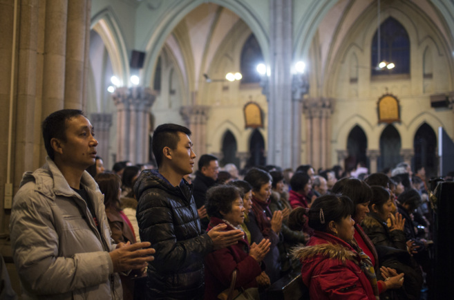 Catlicos rezando en la iglesia de Xujiahui en una misa de...