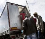 Inmigrantes suben a un camin para acceder al Eurotnel en Calais en...