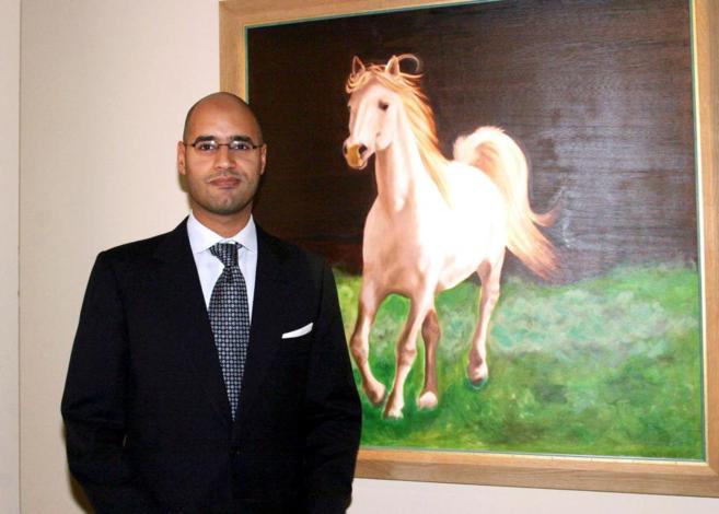 Saif al-Islam junto a uno de sus cuadros.