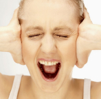 Una mujer se tapa los odos mientras grita para no escuchar.