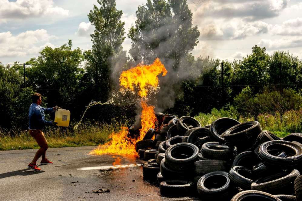 Uno de los huelguista prende fuego a unos neumáticos en Calais.