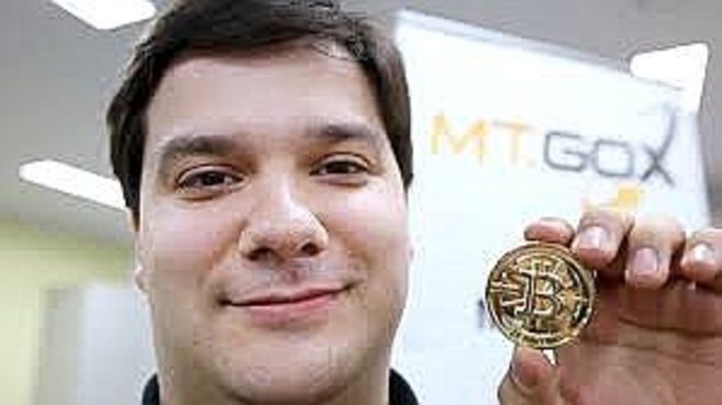Mark Karpeles junto a un bitcoin.