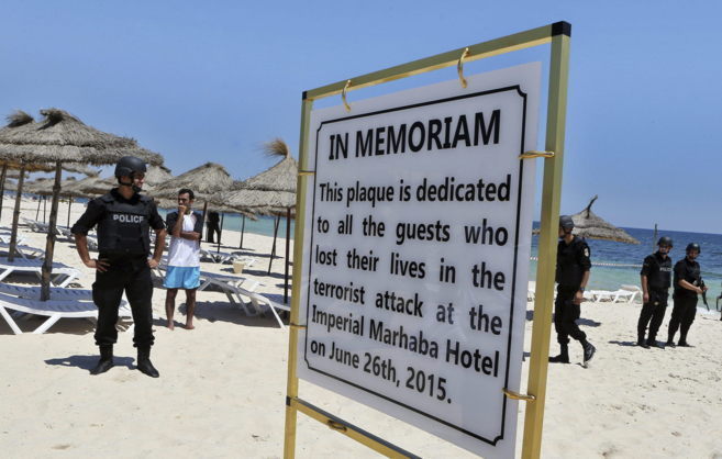 La polica vigila las playas en Susa, donde hay un cartel en homenaje...