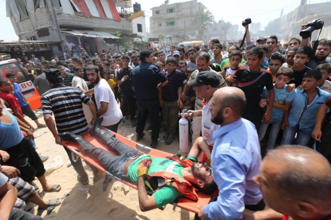 Uno de los heridos es transportado a la ambulancia en Rafah.