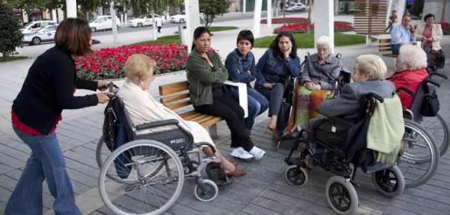 Mujeres latinoamericanas trabajan cuidando a personas mayores, en la...
