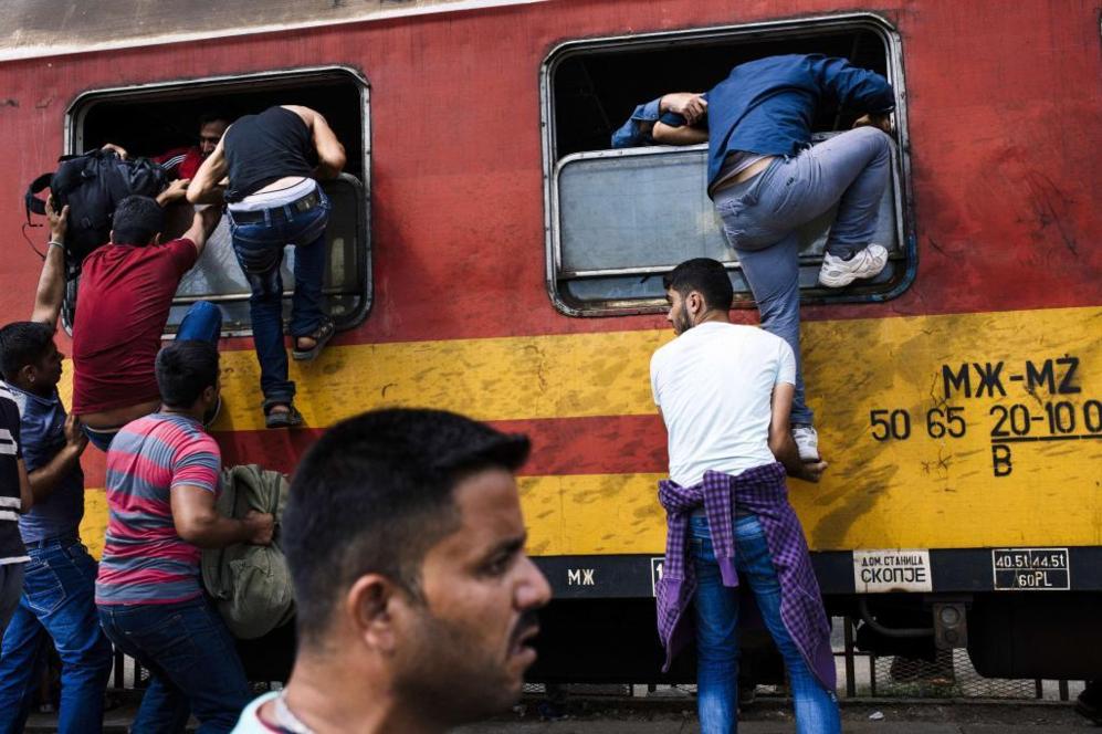 Migrantes intentan abordar un tren que se dirige a la frontera con...