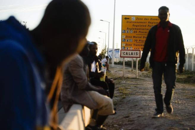 Varios inmigrantes esperan en los alrededores del tnel de Calais.