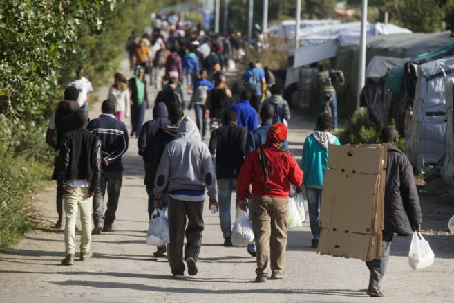 Varios inmigrantes en un campamento cerca de Calais, donde se preparan...