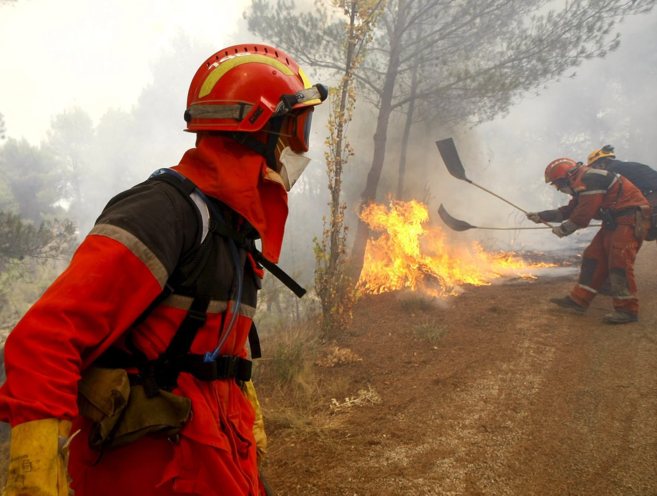 Equipo de bomberos combaten las llamas en el incendio de Torremanzanas...