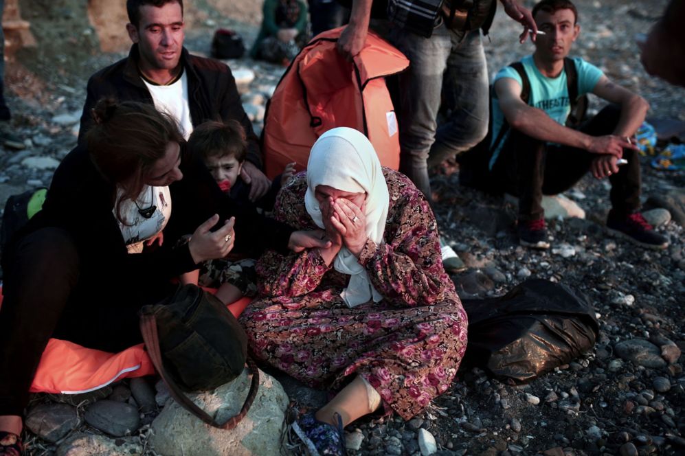 Una refugiada intenta consolar a una señora que llora tras llegar a...