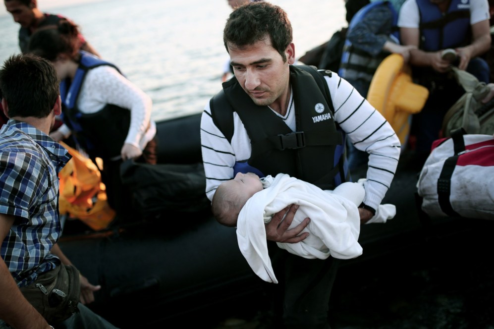 Un hombre sale del bote hinchable sosteniendo a un bebé.