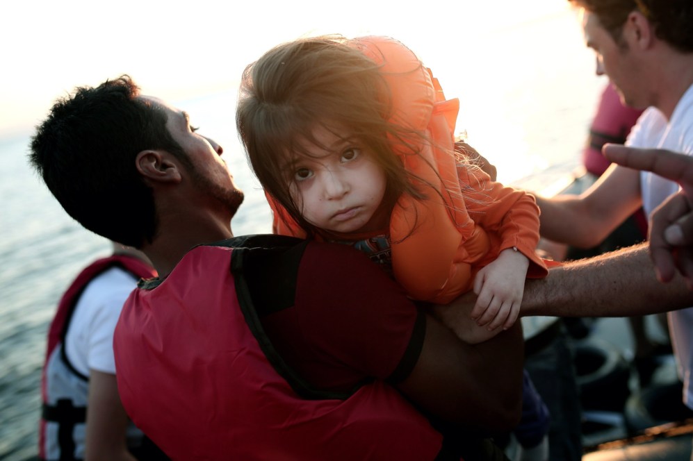 Una niña siria mira fijamente a la cámara desembarcando de la lancha...