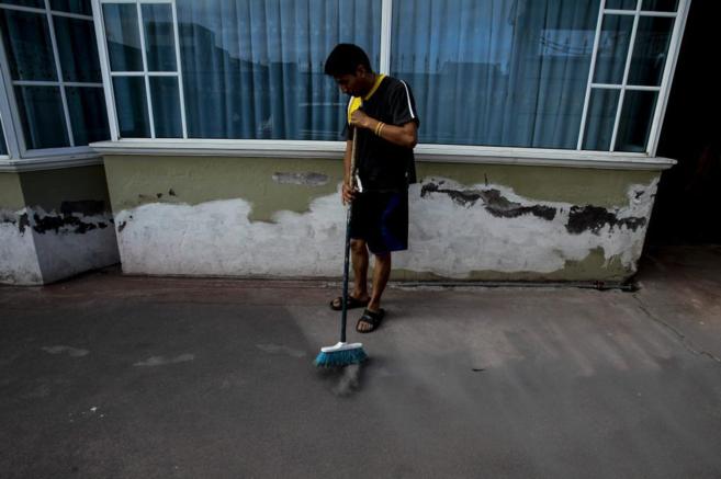 Un ciudadano ecuatoriano barre el patio de su casa en Machachi, lleno...