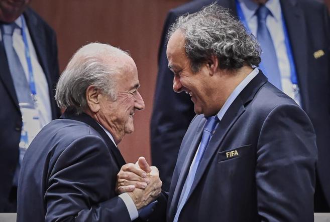 Joseph Blatter (izda) y Michel Platini se estrechan la mano.