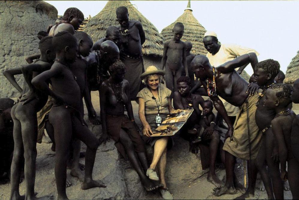 Leni Riefenstahl enseña un libro de fotografías a la tribu de los...