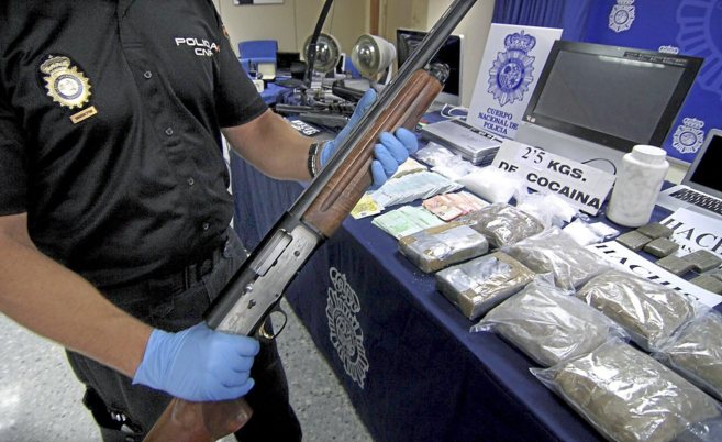 Un agente de la Polica muestra ayer las armas y droga incautadas a...
